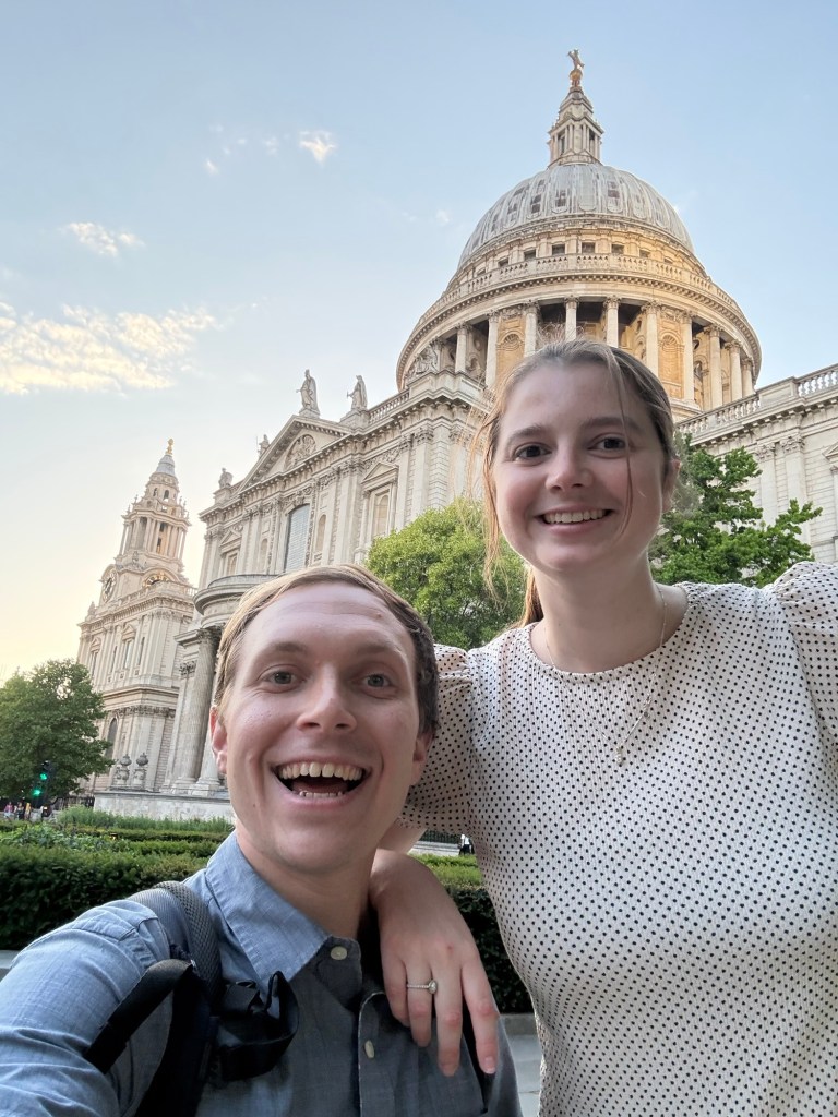 Emily and Bryson smiling in front of St Paul’s Cathedral in London